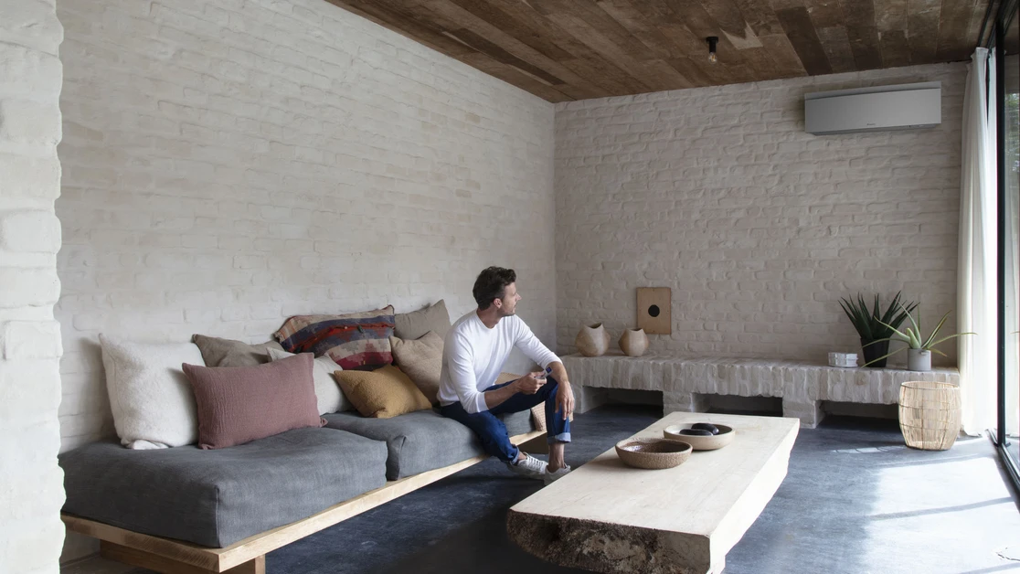 Pohled na naleštěné, plně funkční tepelné čerpadlo před stěnou domu.